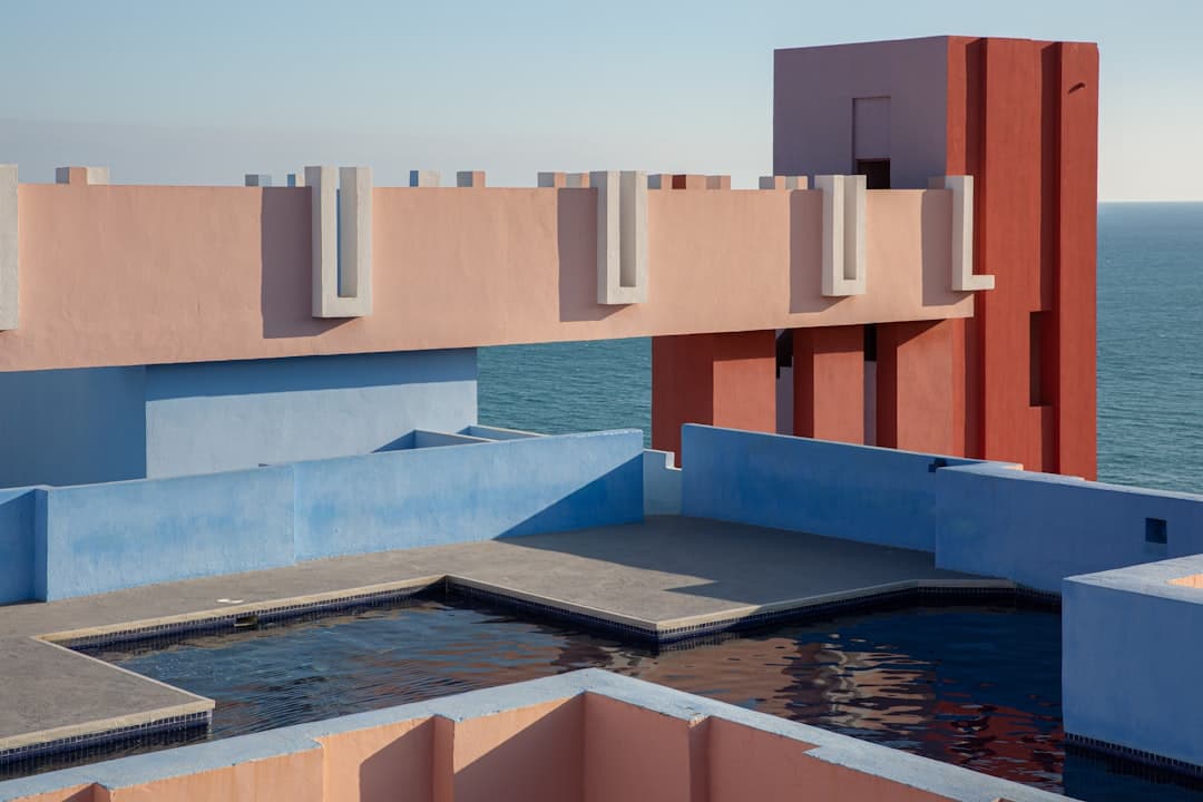 Casa de concreto blanco y marrón con techo plano y jardín, en el chat de Calp