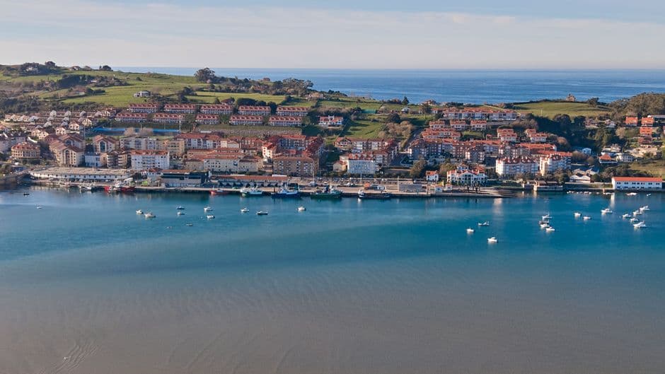 Vista aérea de pueblo costero con casas y mar, en la sala de chat de Erandio