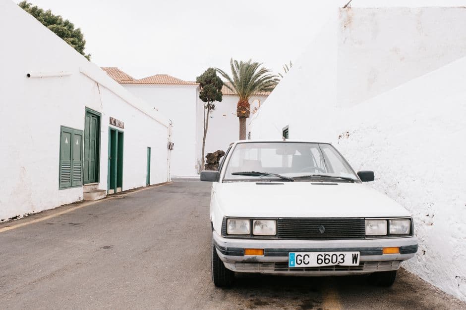 Un coche blanco estacionado en una calle estrecha, en la sala de chat de Teguise