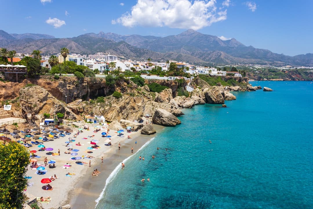 Grupo de personas disfrutando la playa bajo el sol, en el chat de Nerja