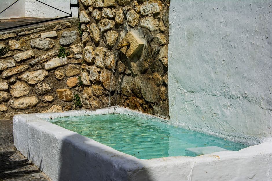 Pilar de piedra bajo un cielo azul con nubes, en la sala de chat de Torrox