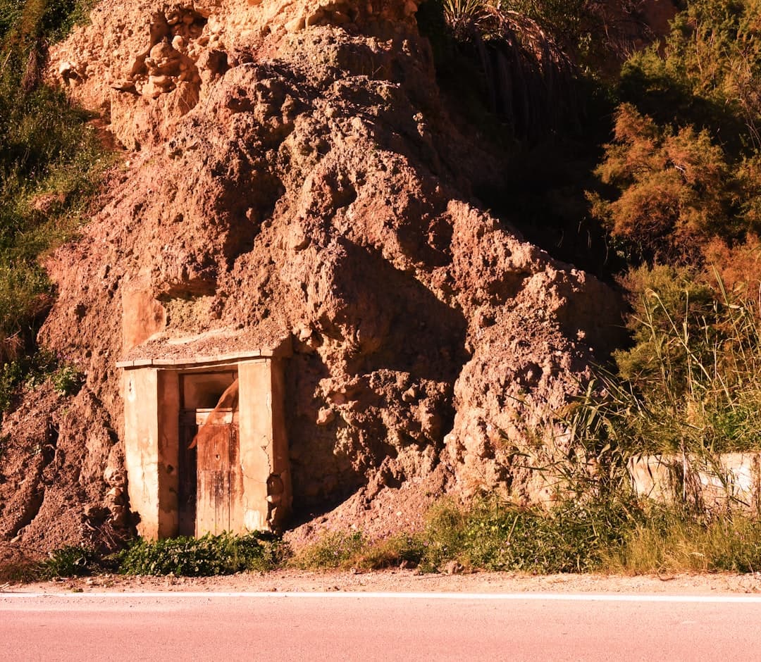 Formación rocosa marrón junto a hierba verde bajo luz diurna, en el chat de Archena