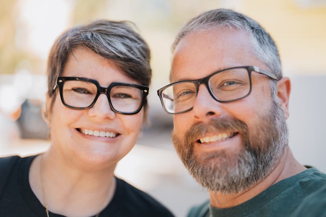 Pareja sonriente con gafas al aire libre, en la sala de chat de Más de 50