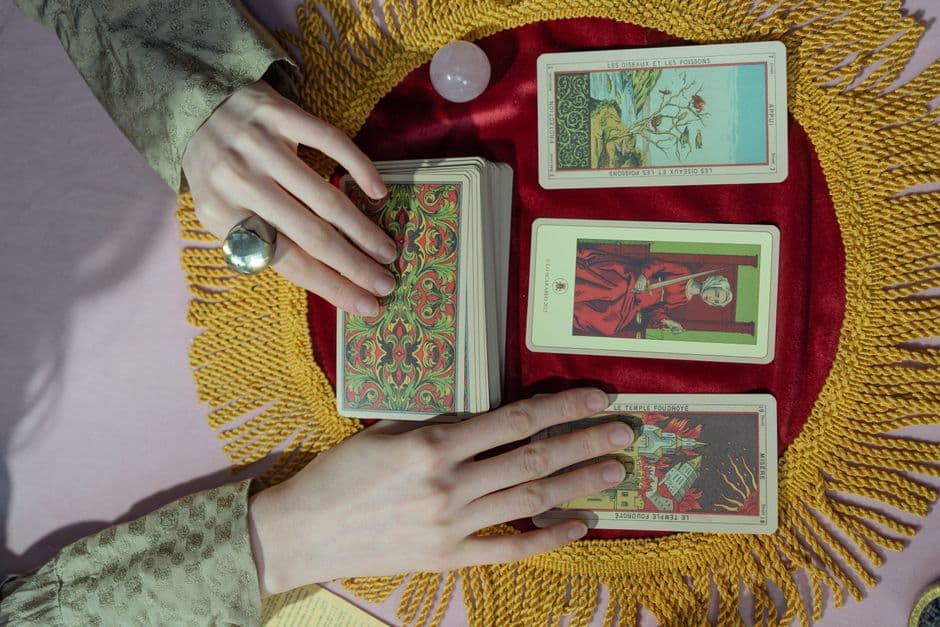 Mano sosteniendo cartas de tarot sobre una mesa, en la sala de chat de Tarot interactivo