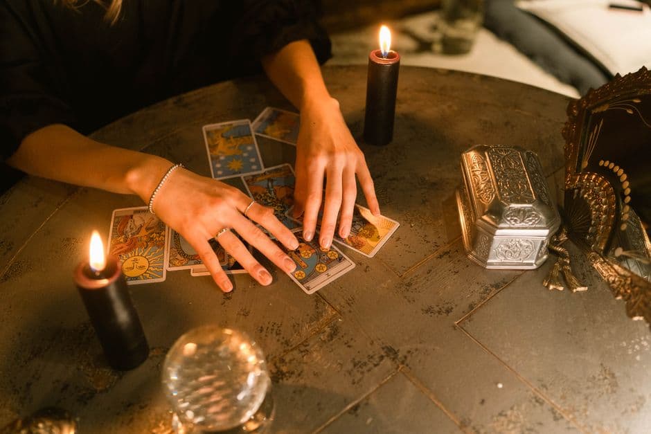 Manos tocando cartas de tarot sobre la mesa, en la sala de chat de Brujería