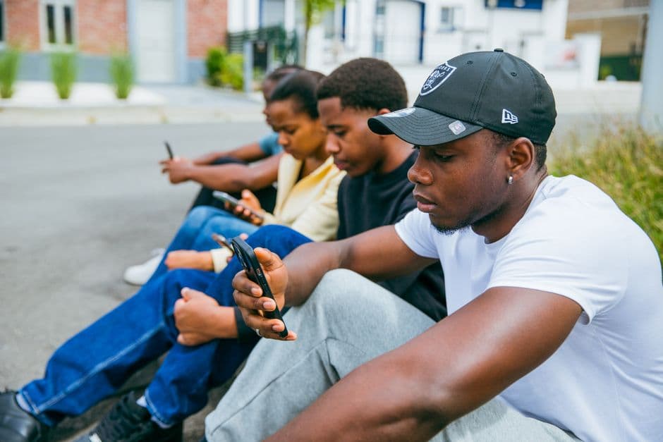 Jóvenes adultos utilizan sus teléfonos móviles al aire libre, en la sala de chat de De 18 a 25