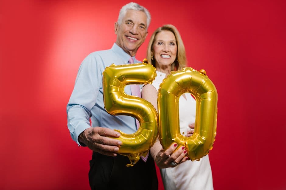 Pareja cincuenta años sonriendo con globos, en la sala de chat de De 50 a 60