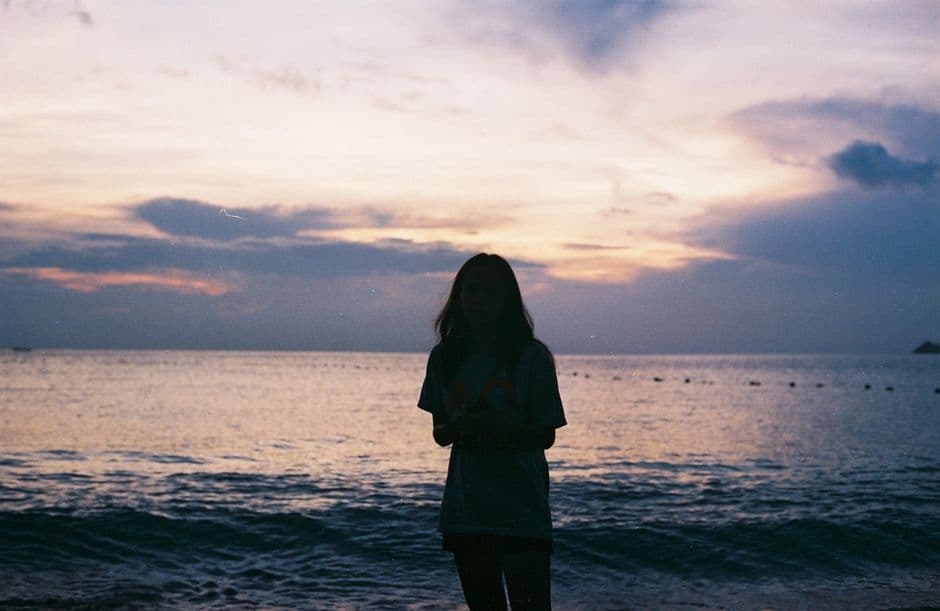 Silueta de mujer junto al mar al atardecer, en la sala de chat de Nudismo