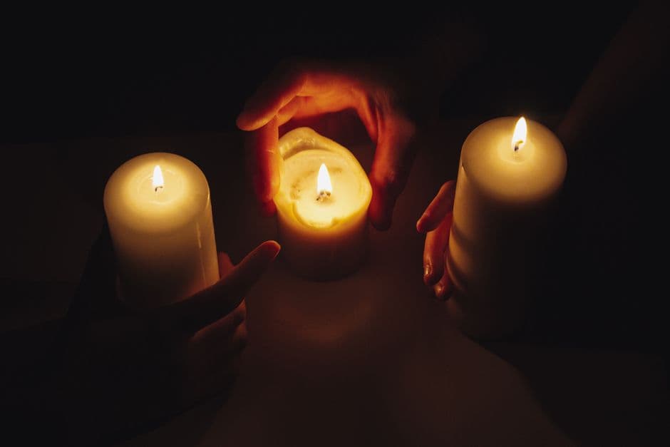Manos en oración sobre vela encendida, luz tenue, en la sala de chat de Evangélicos