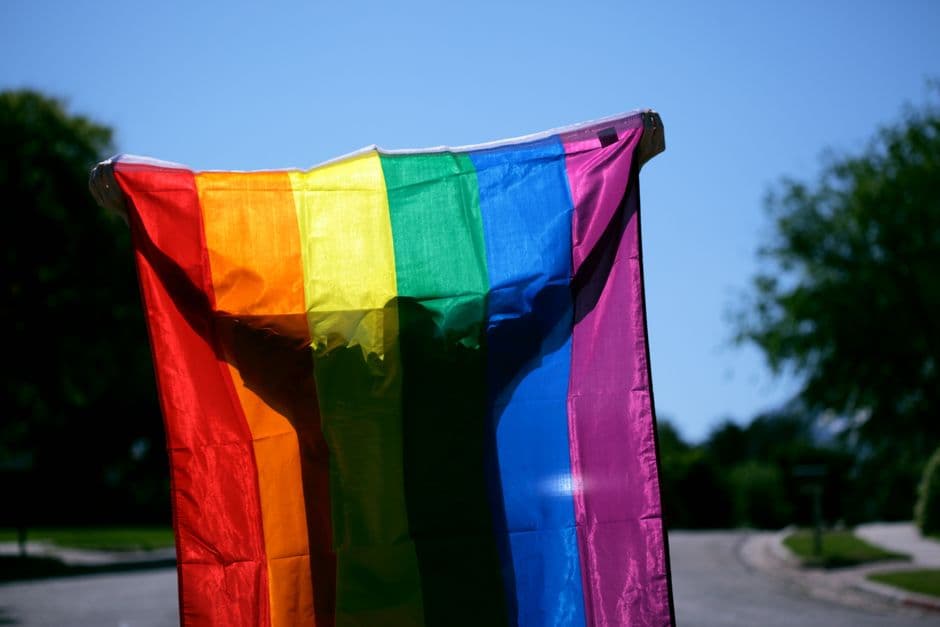 Persona sosteniendo una bandera arcoíris, en el chat de Chueca Madrid