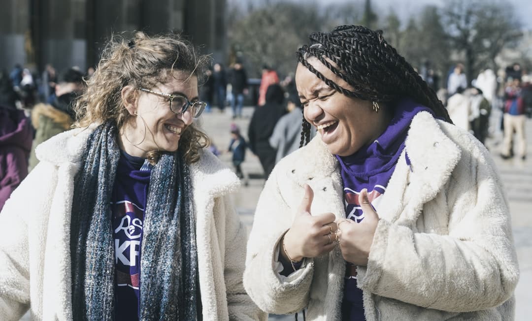 Dos mujeres de pie juntas, sonriendo y riendo, en la sala de chat de Azar