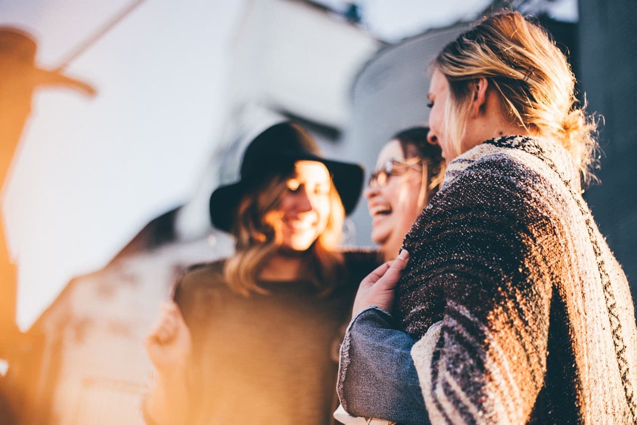 Mujeres sonrientes celebrando, charlando y riendo juntas, en la sala de chat de Avenue