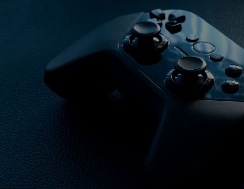 Controlador de videojuegos negro sobre fondo claro, en la sala de chat de Juegos