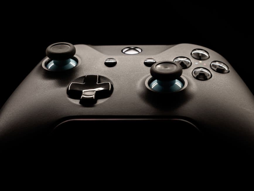 Control de videojuegos Xbox con botones y joysticks resaltados, en la sala de chat de Xbox