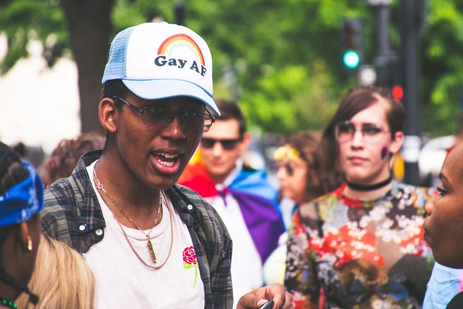 Hombre con camiseta y mujer, ondeando bandera arcoíris, en la sala de chat de Personas trans