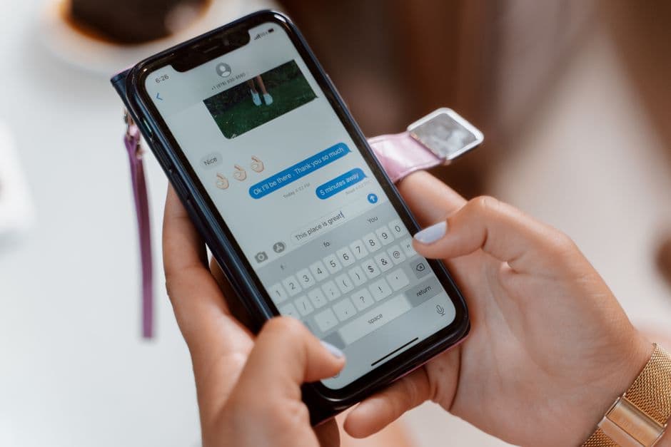 Mano con smartphone escribe mensaje en pantalla, en la sala de chat de Grupos de Telegram