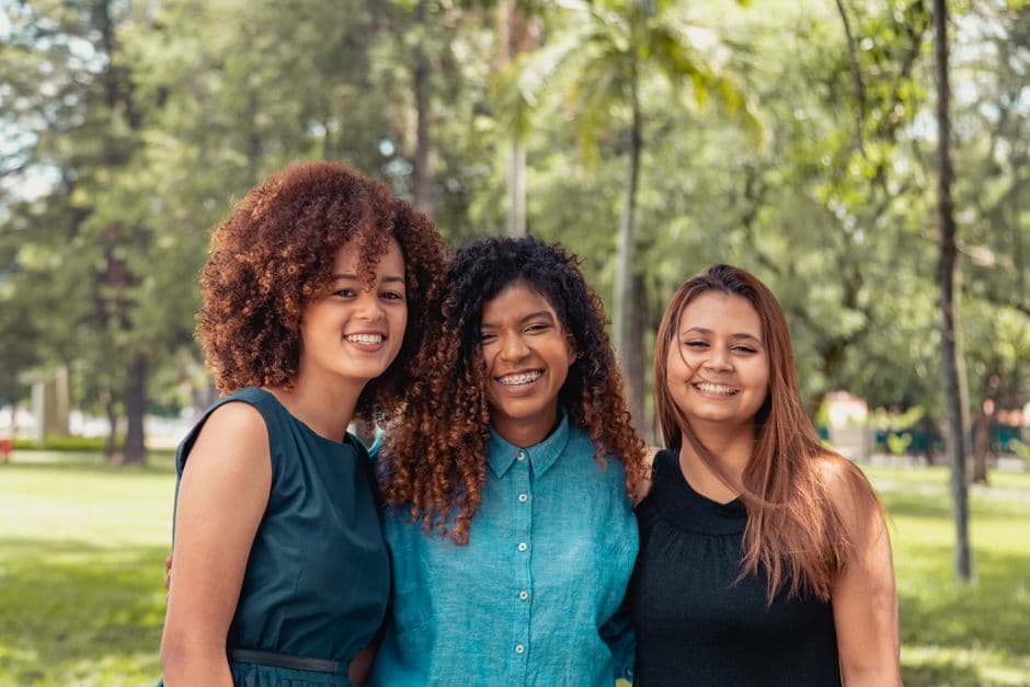 Grupo de amigas latinoamericanas sonriendo juntas, en la sala de chat de ChatLatinos