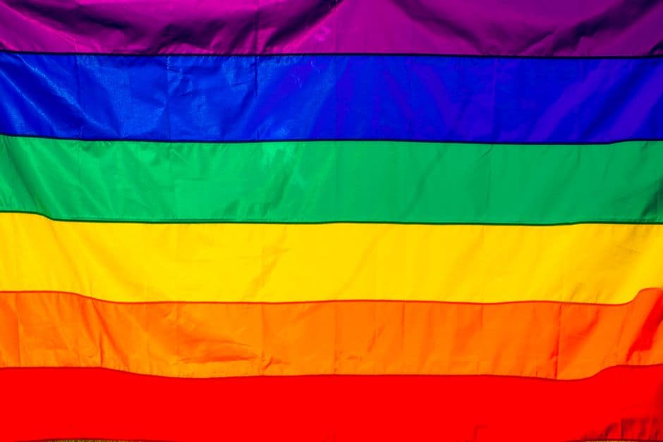 Bandera arcoíris vibrante ondeando con colores intensos, en la sala de chat de Chueca Zaragoza