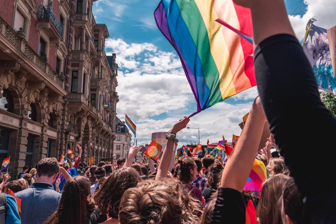 Un grupo de personas sostiene una bandera arcoíris, en la sala de chat de Chueca Torremolinos