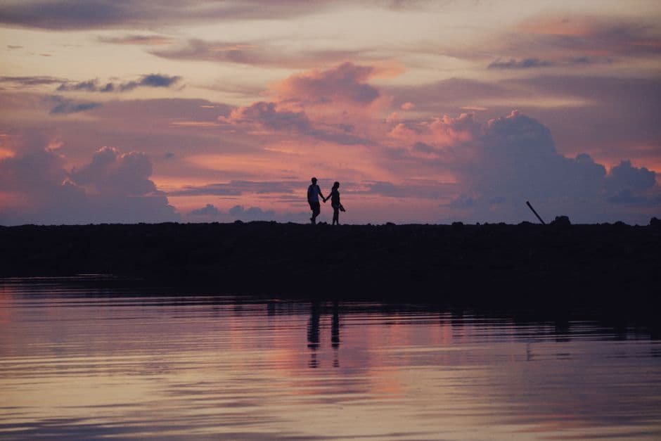 Silhoueta de pareja tomados de mano junto al lago, en la sala de chat de Amas
