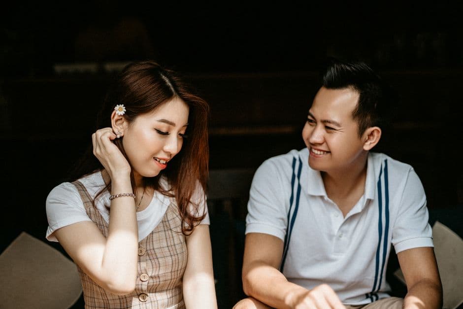 Pareja asiática feliz conversando en una cafetería, en la sala de chat de Solteros