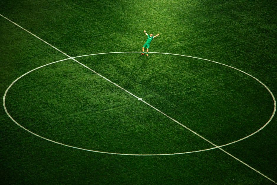 Jugador de fútbol corriendo sobre el césped verde, en la sala de chat de Girona FC