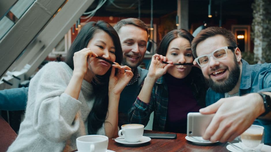 Amigos se ríen y se hacen un selfie en una pausa para el café, en la sala de chat de Colegas