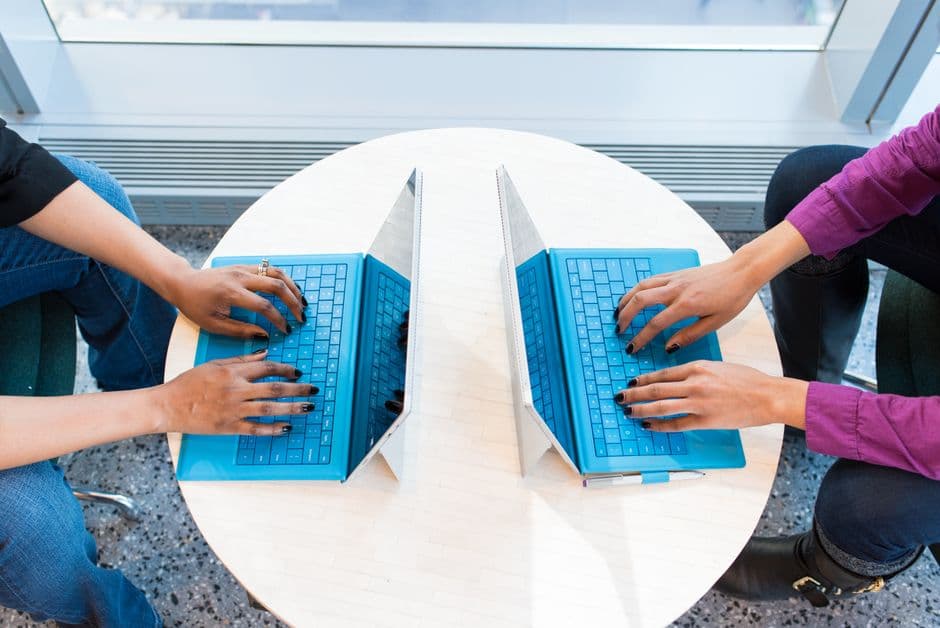 Dos personas trabajando en portátiles, en la sala de chat de Empleo