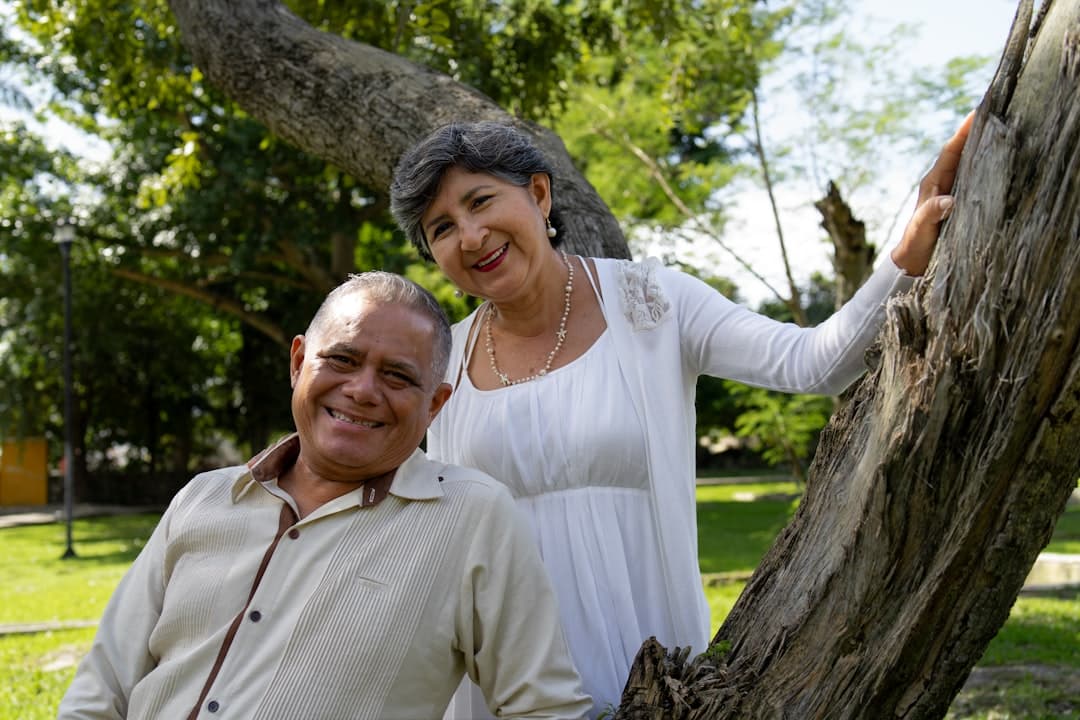 Pareja sonriente posa junto a árbol, en la sala de chat de Latinchat más de 50