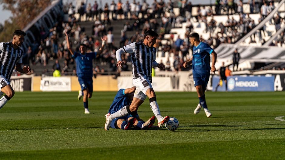 Partido intenso de fútbol en campo verde brillante, en la sala de chat de Olé