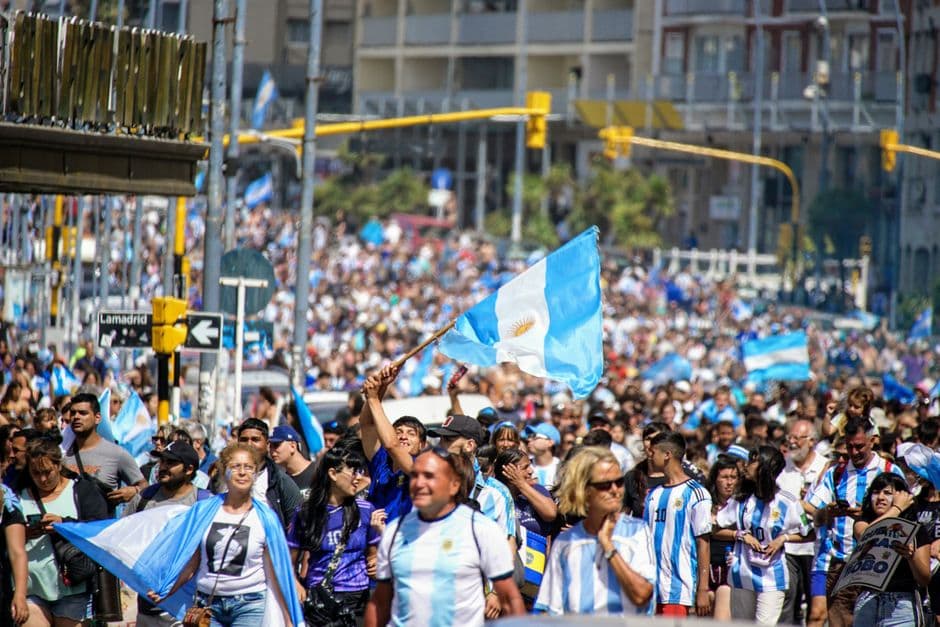 Multitud agitando bandera argentina en una calle, en la sala de chat de Libre Argentina
