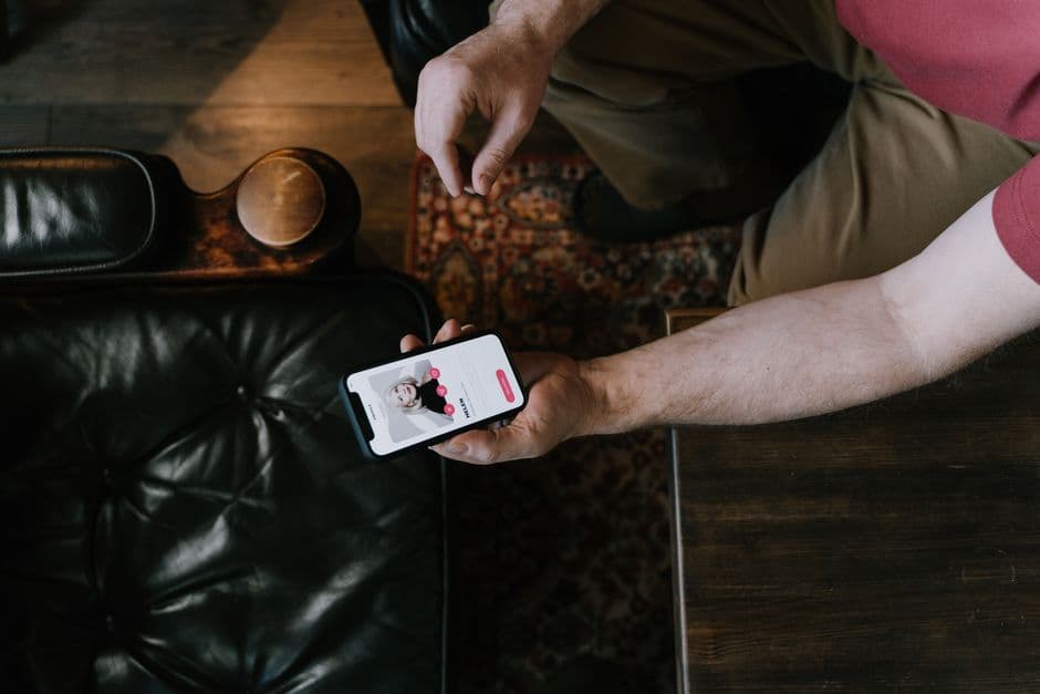 Mano sosteniendo smartphone con app de citas, en la sala de chat de Badoo Argentina