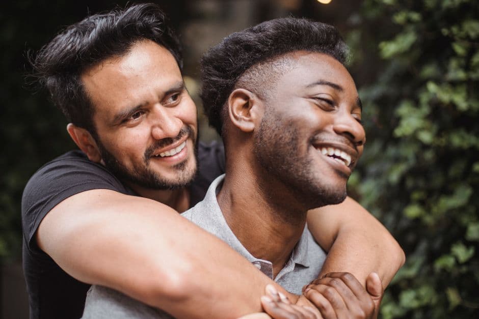 Dos hombres se abrazan sonriendo, en la sala de chat de Gay Madrid