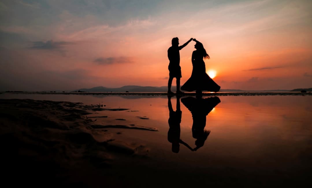 Pareja en silueta besándose en la playa al atardecer, en la sala de chat de Amor