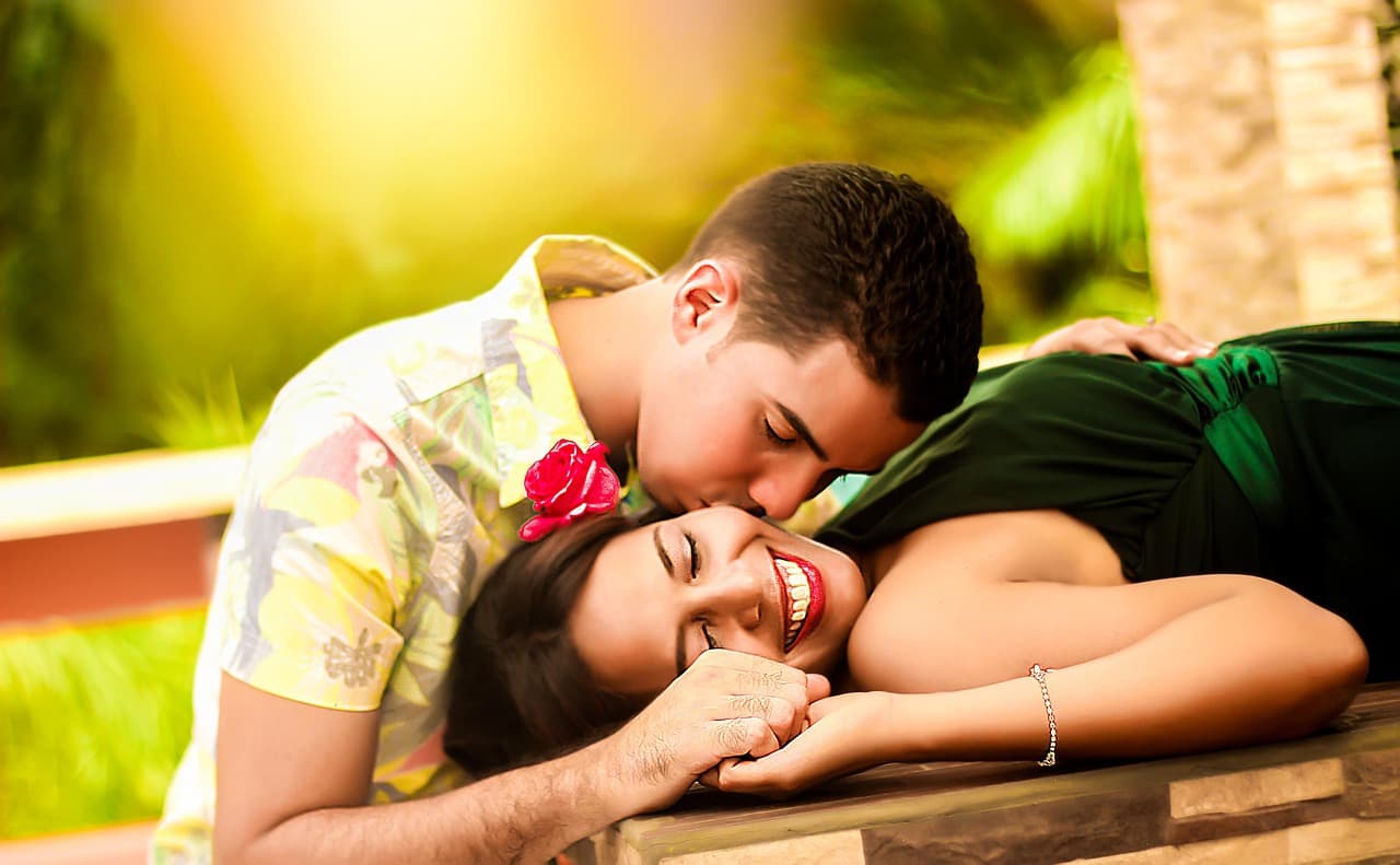 Pareja gay besándose y yaciendo relajada, sonriendo, en la sala de chat de Chat Gay Sevilla