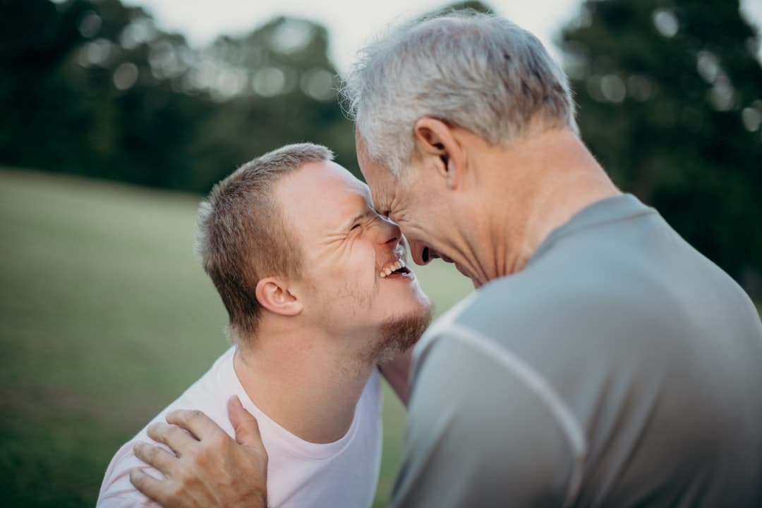 Dos hombres sonrientes conversando en hierba, en la sala de chat de Chat Gay Valencia