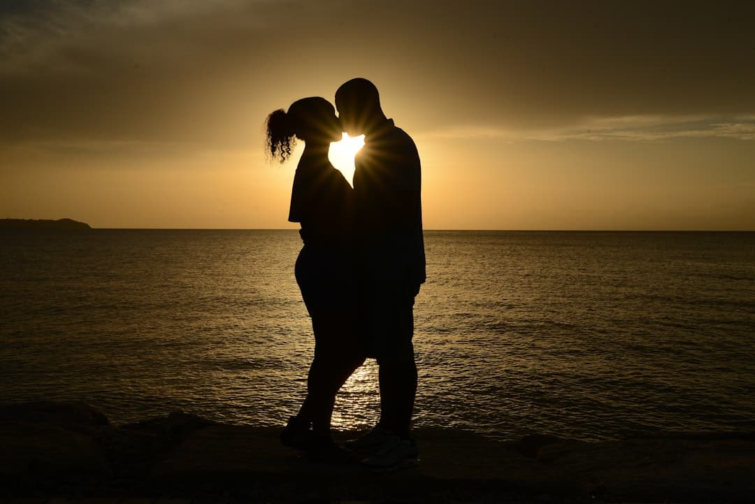 Pareja en silueta besándose bajo un sol brillante, en la sala de chat de Chat Adultos