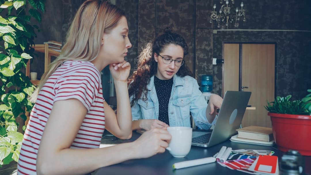 Dos mujeres revisan algo en una laptop, en la sala de chat de Terra Chat Murcia