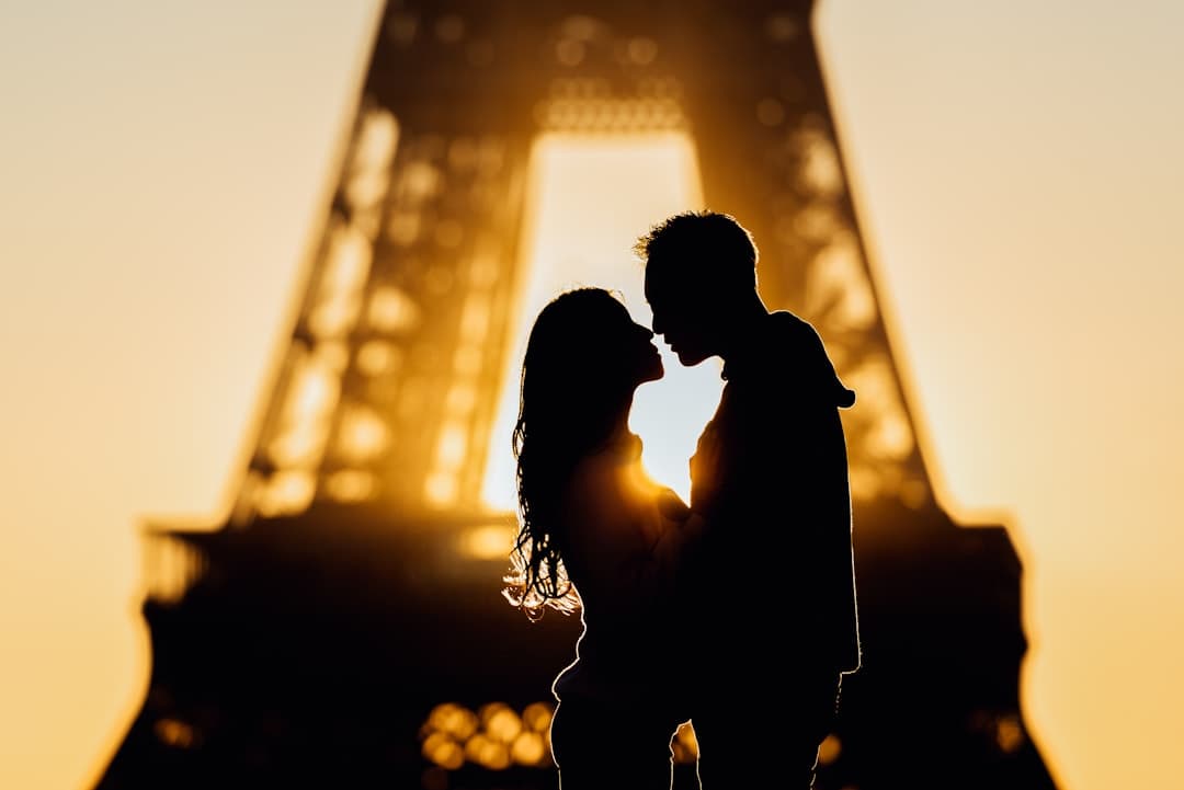Pareja en silueta besándose bajo un atardecer dorado, en la sala de chat de Cornudos liberales