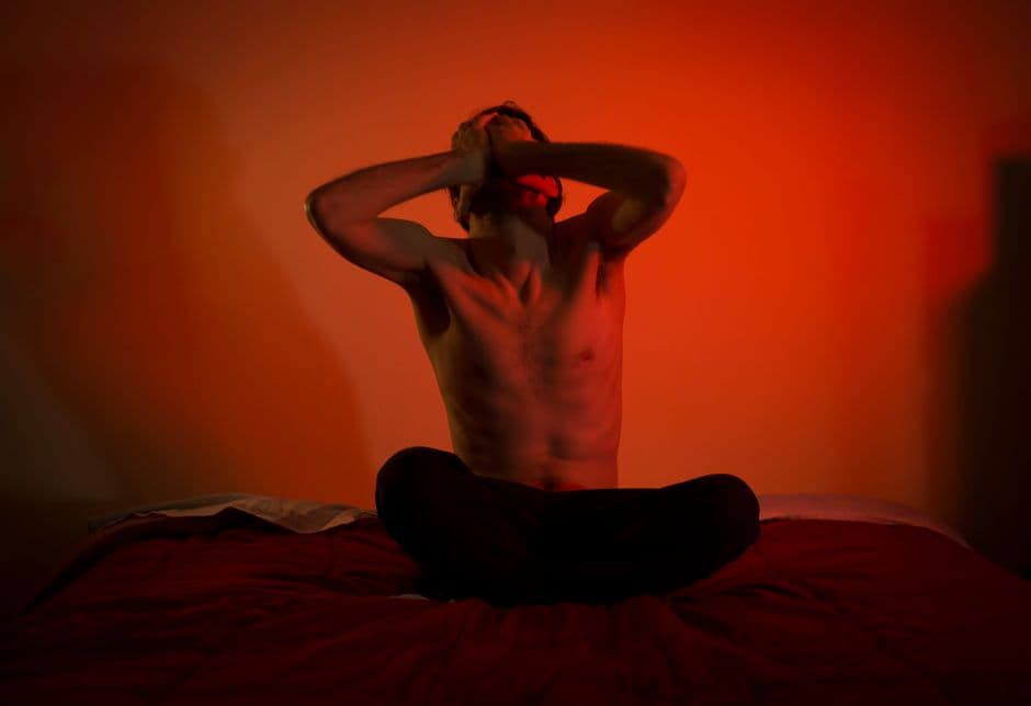Hombre camisa fuera en la cama luz roja, en la sala de chat de Canal Sexo