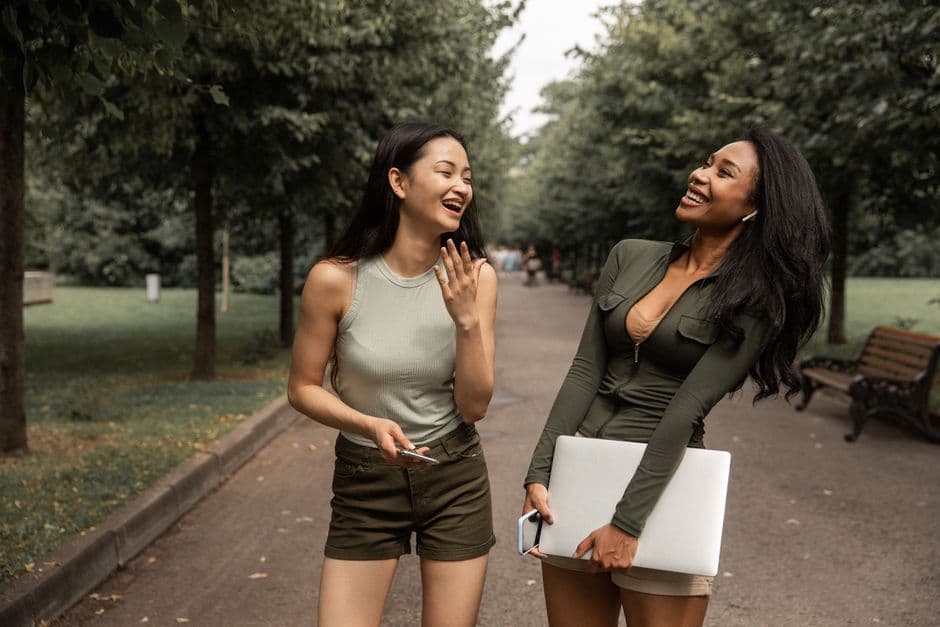 Jóvenes mujeres sonrientes conversan y ríen bajo árboles verdes, en la sala de chat de Chachipén
