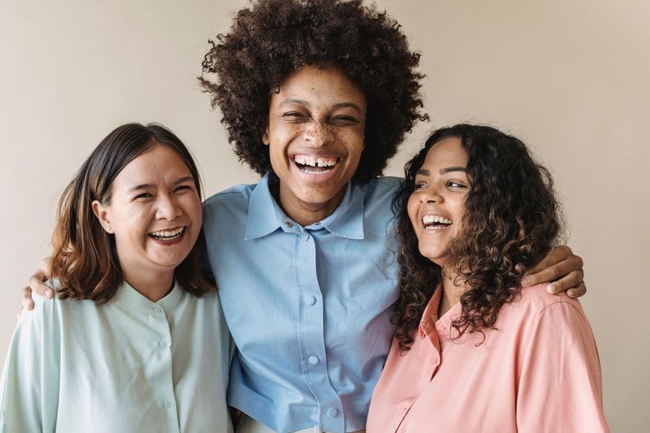Tres mujeres riendo juntas en la sala de chat de Ocio