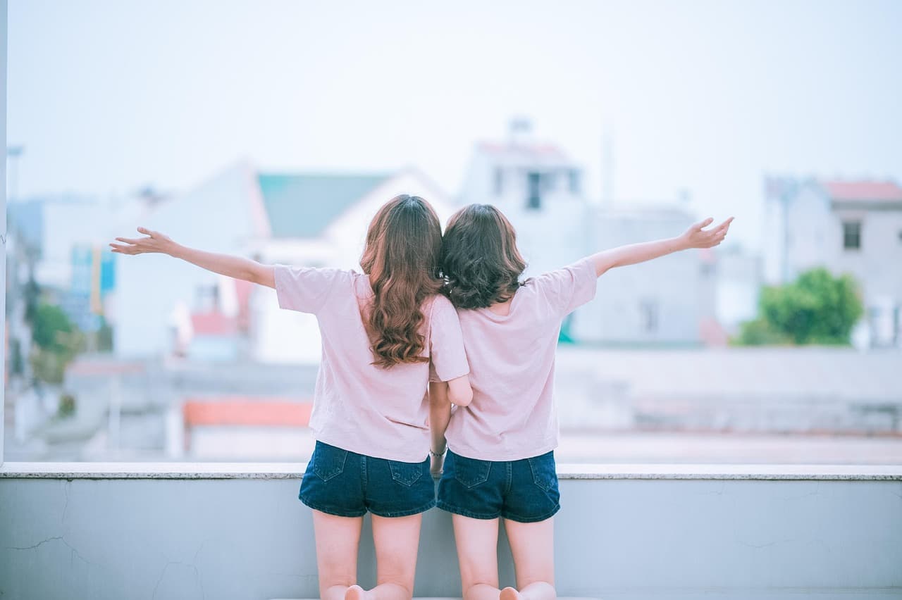Dos mujeres abrazadas y sonriendo, mirando a cámara, en la sala de chat de Lesbianas